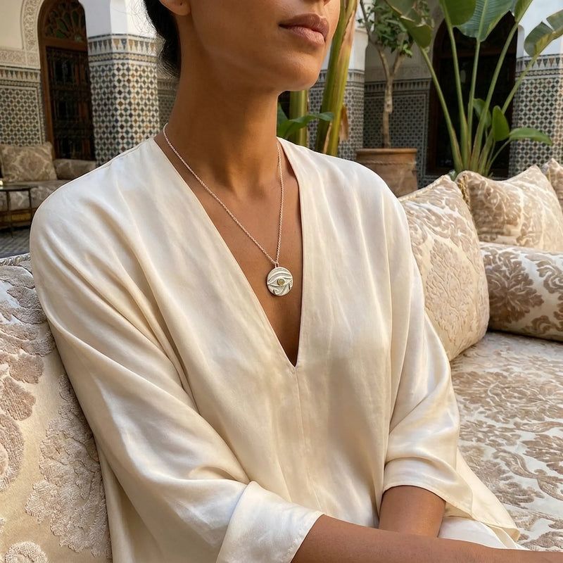Eye of Horus pendant in 925 sterling silver set with a solid natural fire opal, photographed at Al Qasr in Dubai — October birthstone jewellery by Luna Dura.