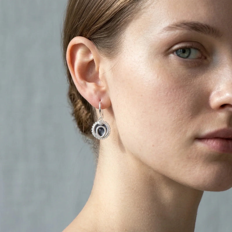 what does the snake eating itself mean, model wearing dangle ouroboros enameled earring in Luna Dura studio in Dubai