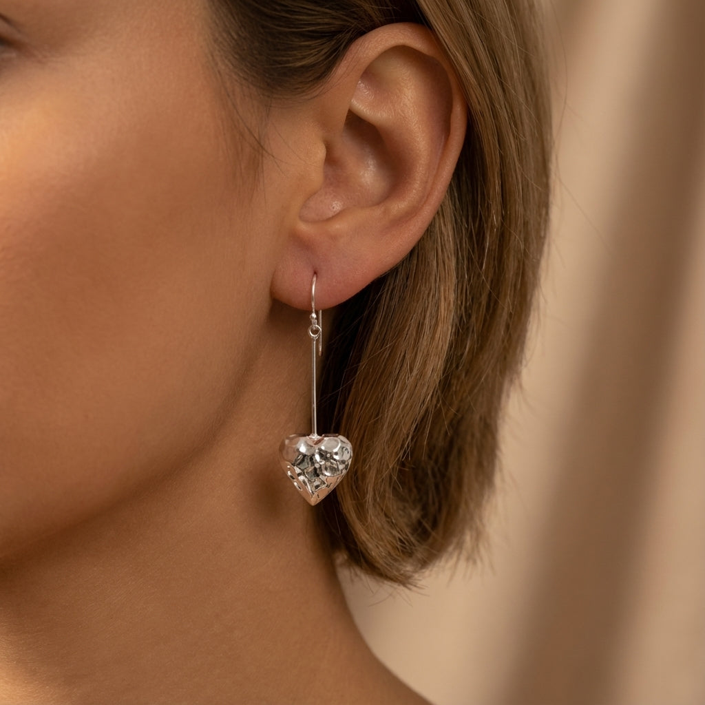 Woman wearing 925 sterling silver hammered heart drop earrings at Luna Dura studio Sheikh Zayed Road Dubai