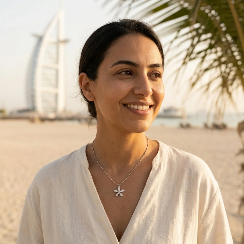 Woman wearing a 925 silver daisy pendant necklace near the Burj Al Arab, a birthday gift in Dubai.