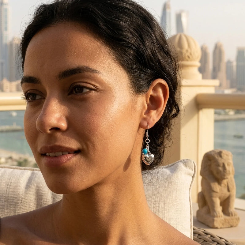 Silver puffed heart bead dangle earrings worn with layered silver necklaces on a sunlit terrace — 925 sterling silver