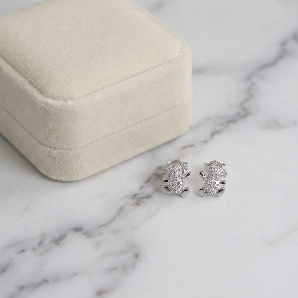 Silver teddy bear earrings displayed inside a velvet presentation box for delivery in Dubai.