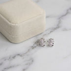 Silver teddy bear earrings displayed inside a velvet presentation box for delivery in Dubai.
