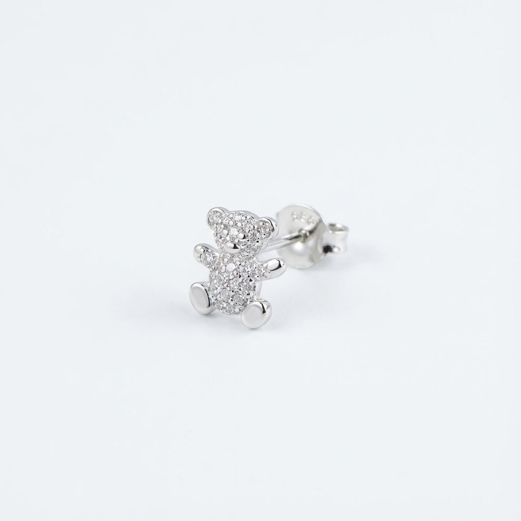 Macro close-up of a rhodium-plated silver teddy bear ear stud in Dubai.