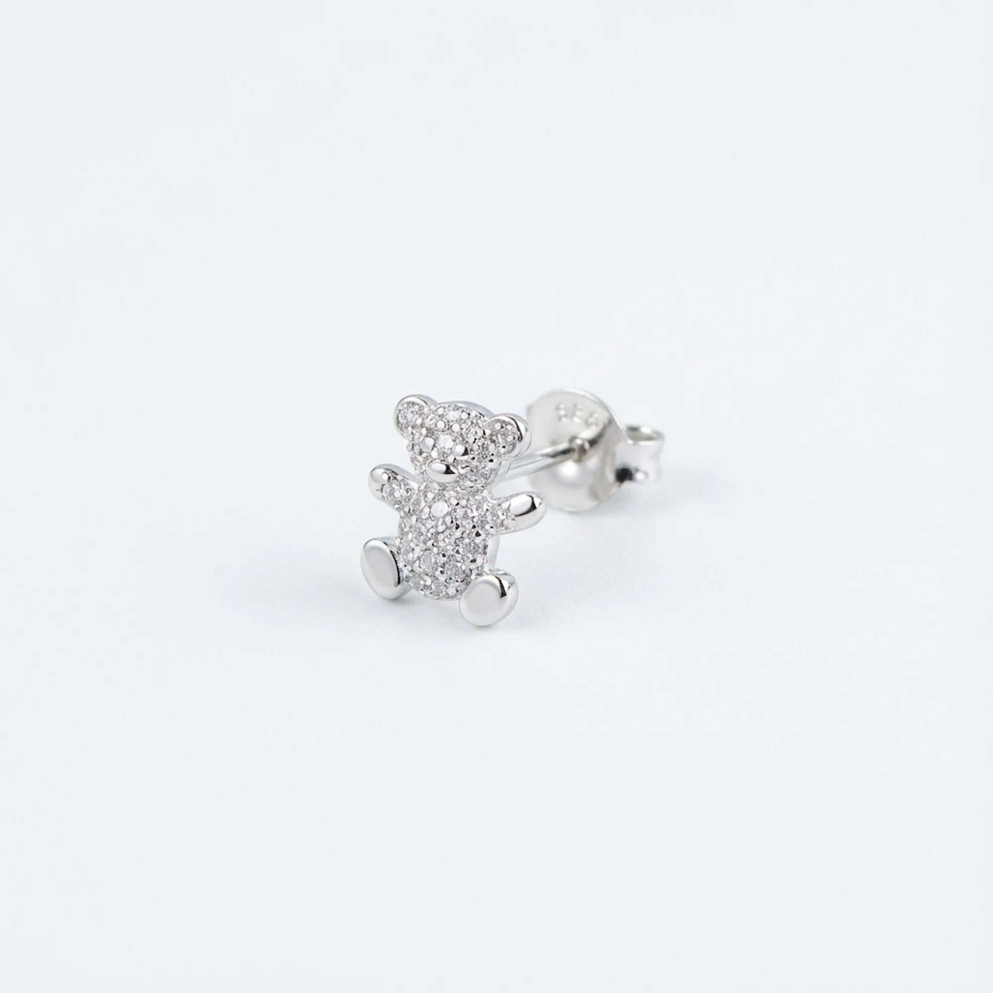 Macro close-up of a rhodium-plated silver teddy bear ear stud in Dubai.