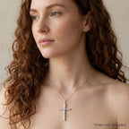 Woman wearing a polished sterling silver crucifix pendant with woodgrain texture, chain not included.