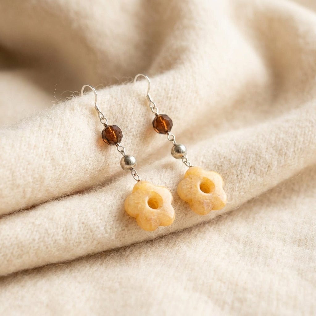 Close-up of hand-carved 5-petal Yellow Carnelian flower with open-center design, polished silver bead, and faceted amber crystal accent — Luna Dura UAE.