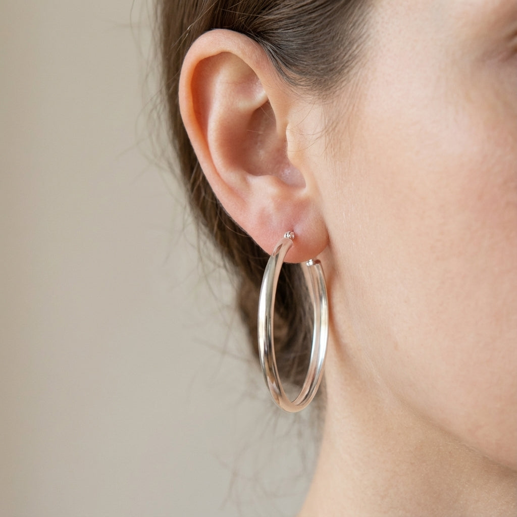 Classic polished silver hoops 5 mm wide, handmade in Dubai worn by model blurred background 