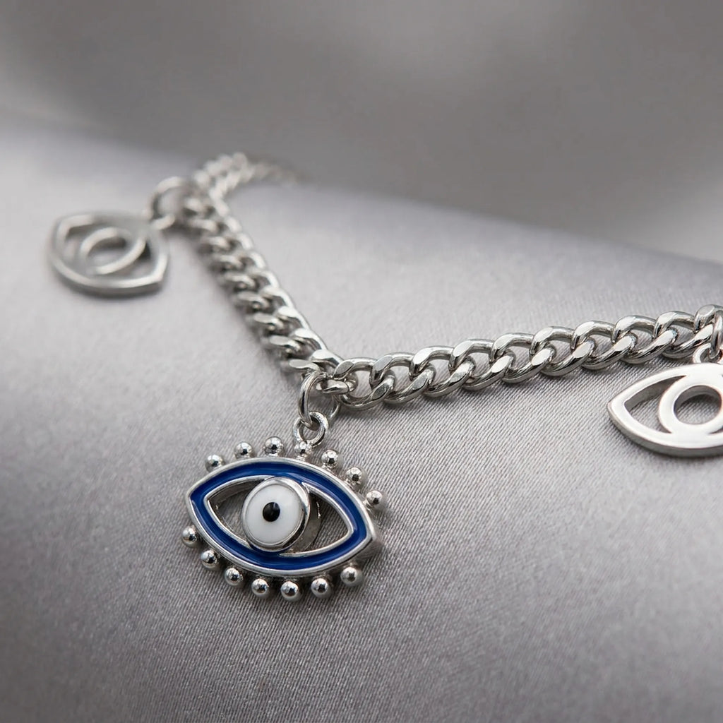 Macro Photo Silver chain necklace with eye-shaped charm on a gray surface
