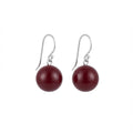 Pair of burgundy  round earrings on silver hooks against a white background in Dubai.