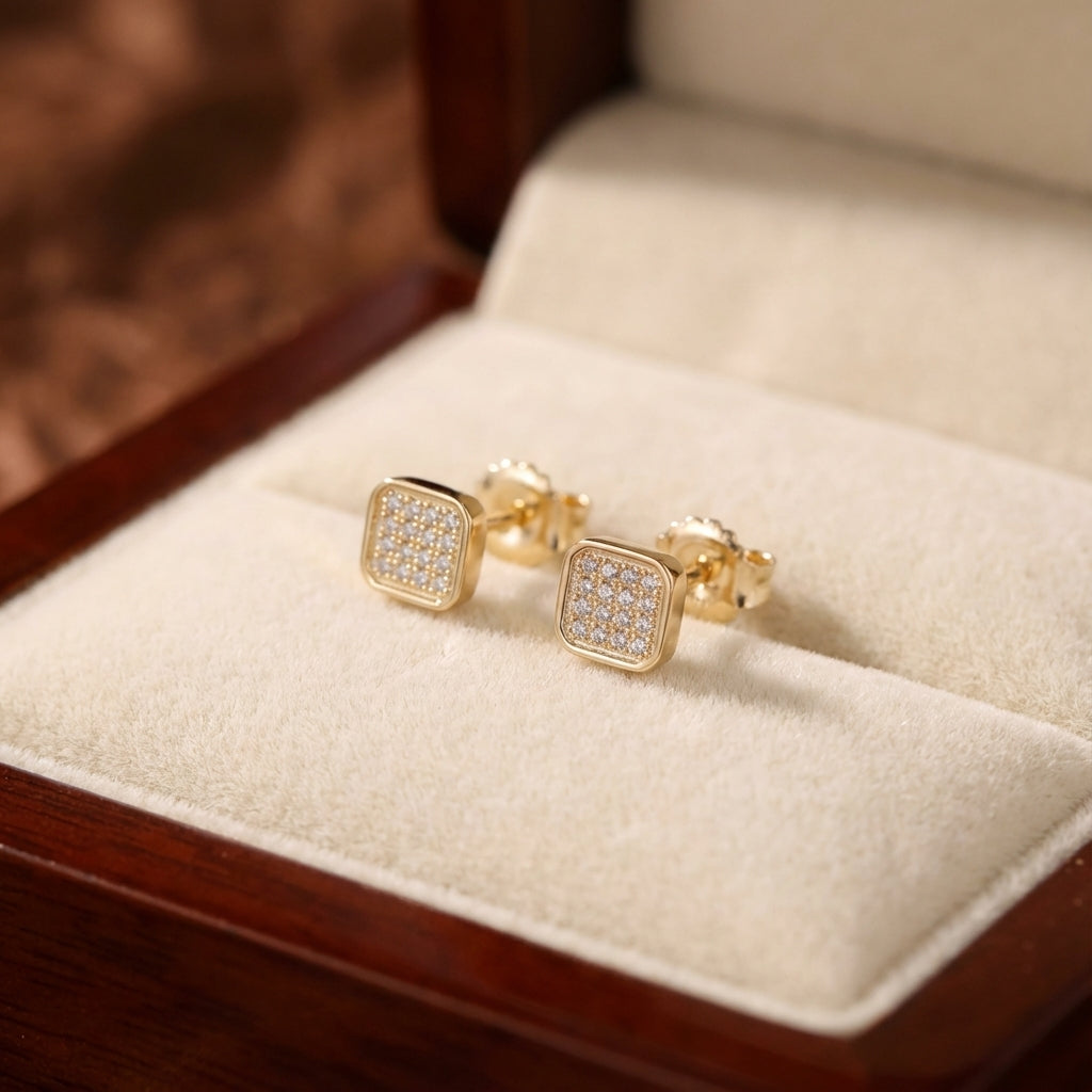 Gold square earrings with embedded stones on a wooden stand Dubai.