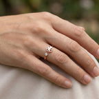 model wearing a ring with a clover design and small cubic zirconia  gemstone on a blurred natural background dubai 