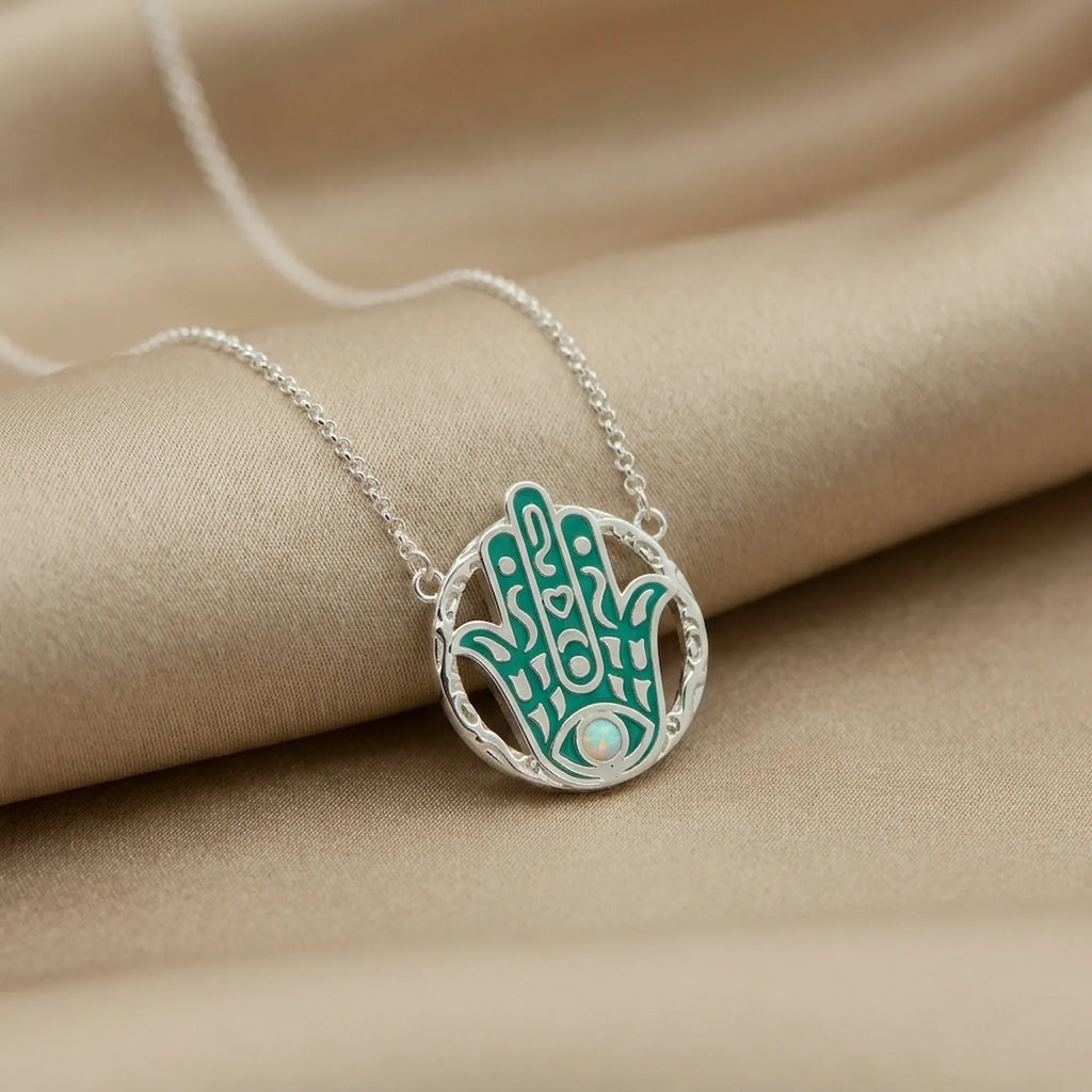 Necklace with a green and silver pendant on beige fabric Macro photo 