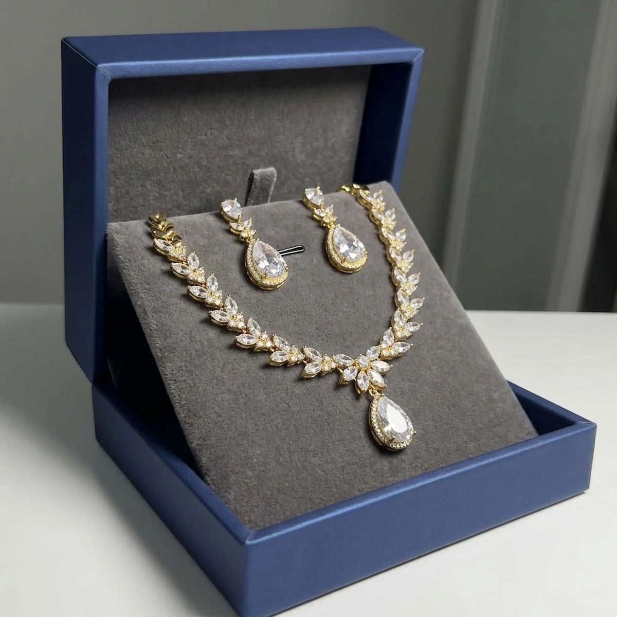18k gold-plated cubic zirconia halo teardrop necklace and earring set displayed in a luxury navy gift box in Dubai.