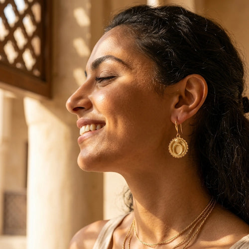 Model wearing 18K gold vermeil ouroboros snake drop earrings featuring a 30 mm drop, styled in Dubai.