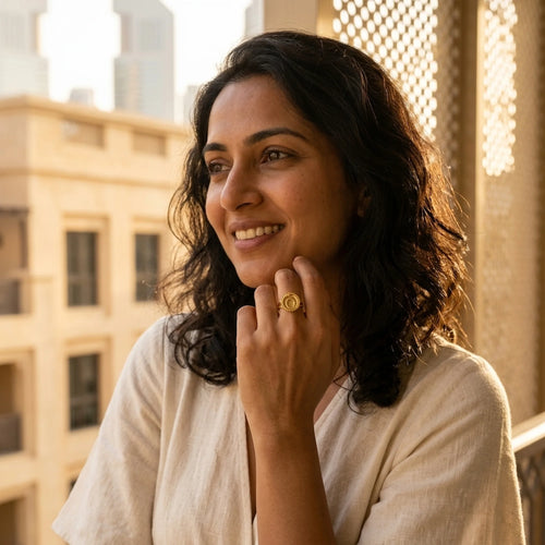Woman wearing the 18K gold vermeil ouroboros snake signet ring over 925 sterling silver outdoors in Dubai.