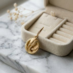 Single 18K gold vermeil tulip drop earring over 925 sterling silver resting on a jewellery box in Dubai.