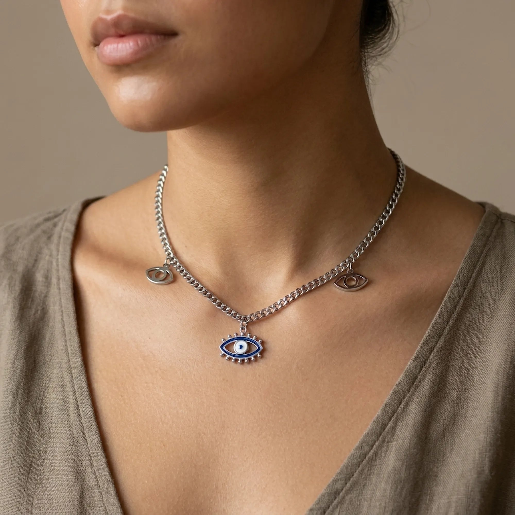 Necklace with an eye-shaped pendant worn by a model against a neutral background