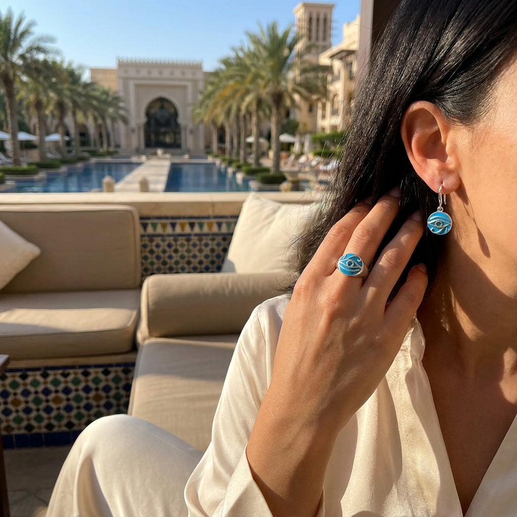Woman adjusting earrings with a pool and resort in the background, to display size fit.