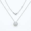 Silver necklace with a round pendant on a white background