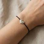 سوار على شكل قلب نابض، مزين بتعليقة مطلية بالفضة