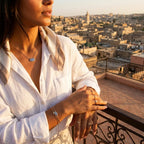 Woman on a balcony overlooking al Seef Heritage street Dubai with a warm glow