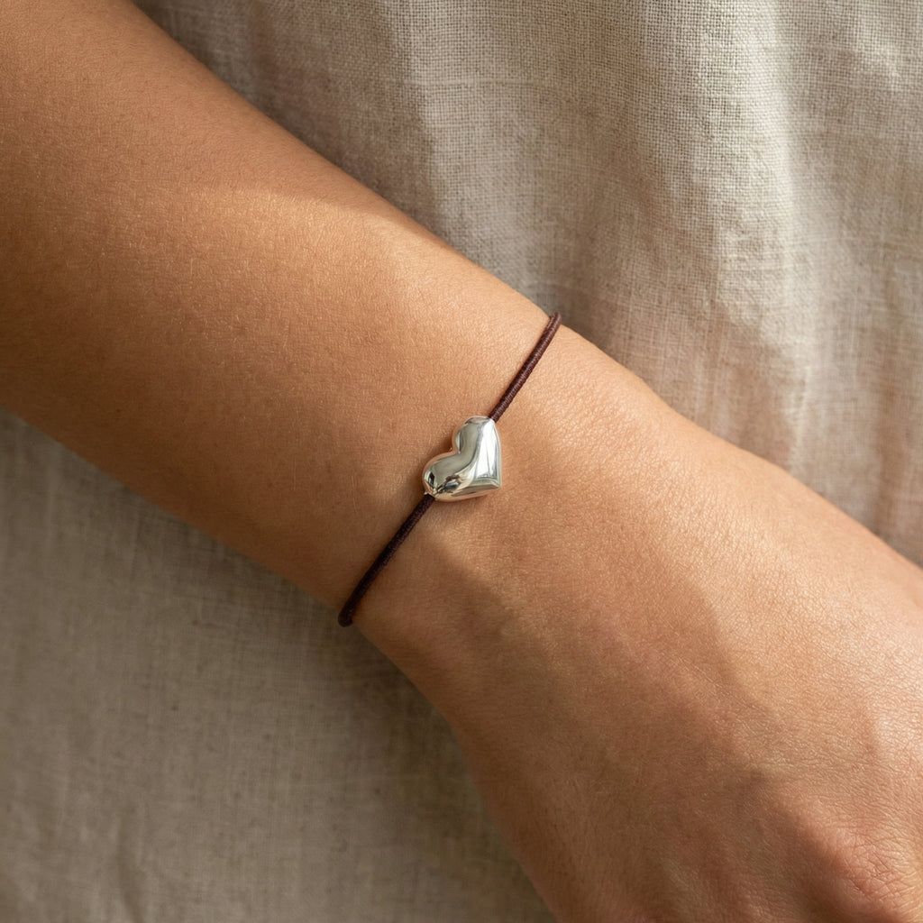 سوار على شكل قلب نابض، مزين بتعليقة مطلية بالفضة