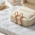 Rose gold four-leaf clover huggie hoop earrings with cubic zirconia, Luna Dura Dubai.