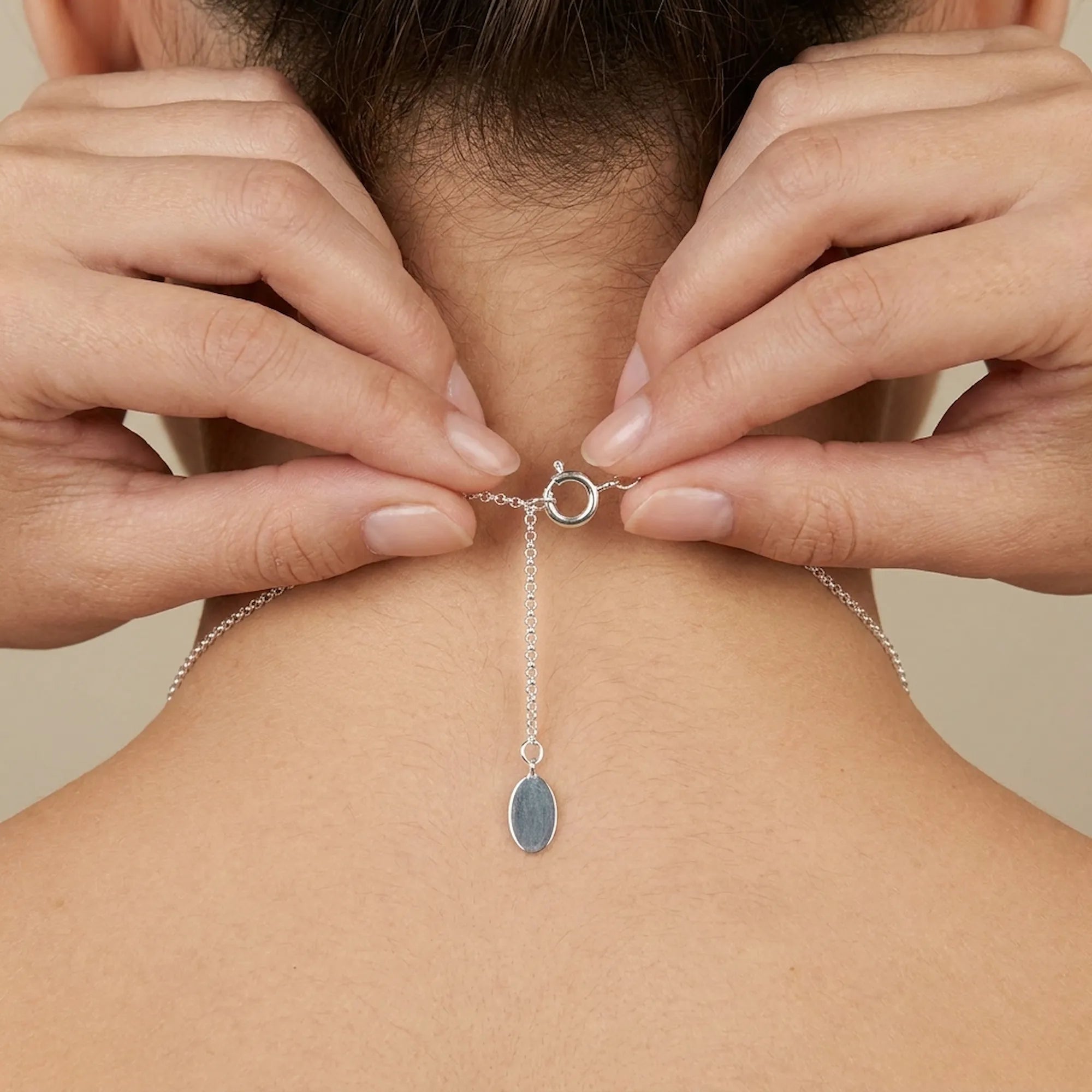 How to wear a silver necklace with a pendant on a neutral background, Sring lock closer