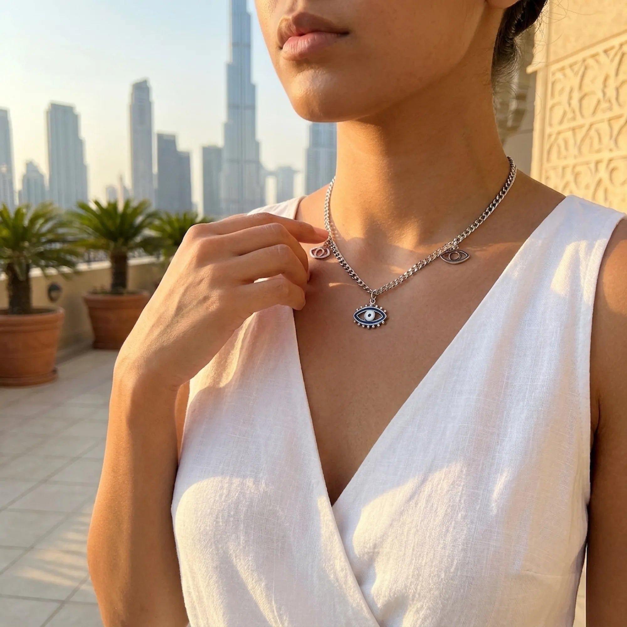 Model wearing a necklace with an eye pendant against a cityscape 2 seasons hotels dubai background