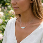 The Dubai Miracle Garden lifestyle model wearing necklace with a feather plume pendant outdoors