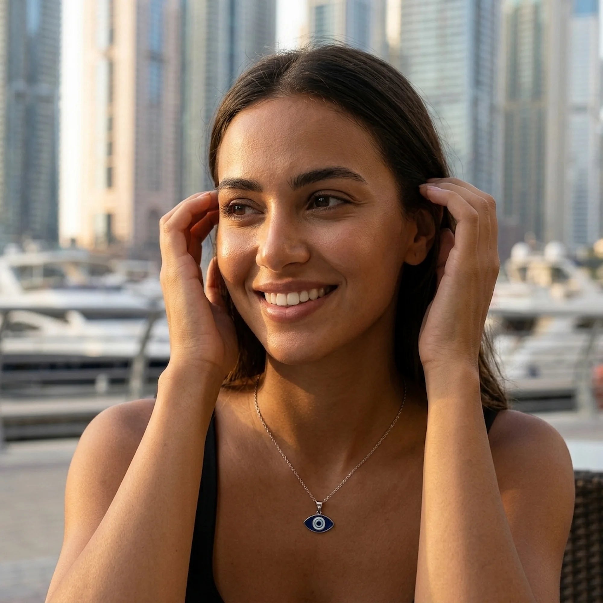 Woman wearing a 925 silver almond evil eye pendant outdoors in Dubai, an everyday protection gift.