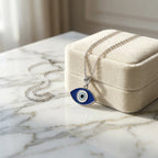 925 silver almond evil eye pendant in blue enamel resting on a jewelry box, a protective gift in Dubai.