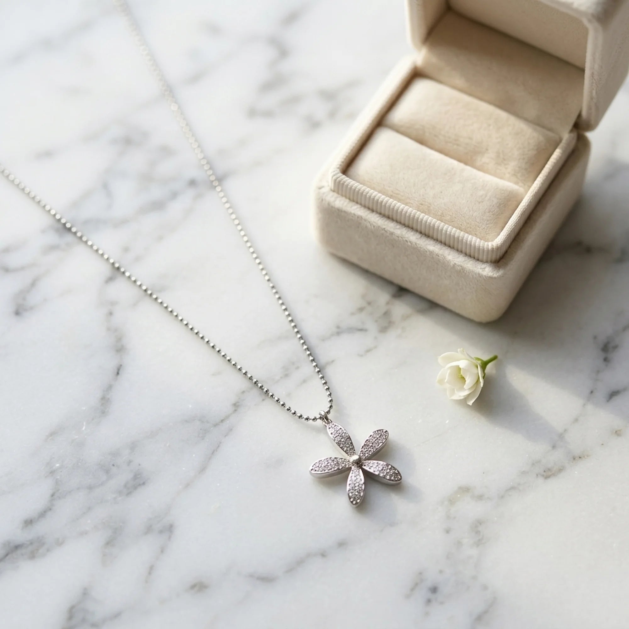 925 silver daisy pendant necklace pavé-set with cubic zirconia near a jewelry box, a gift in Dubai.