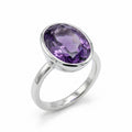 Frontal view of an oval cut amethyst ring set in bright polished 925 sterling silver on a white background UAE.