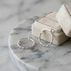 925 silver rope twist stacking hoop earrings resting near a jewelry box, an everyday gift for her in Dubai.