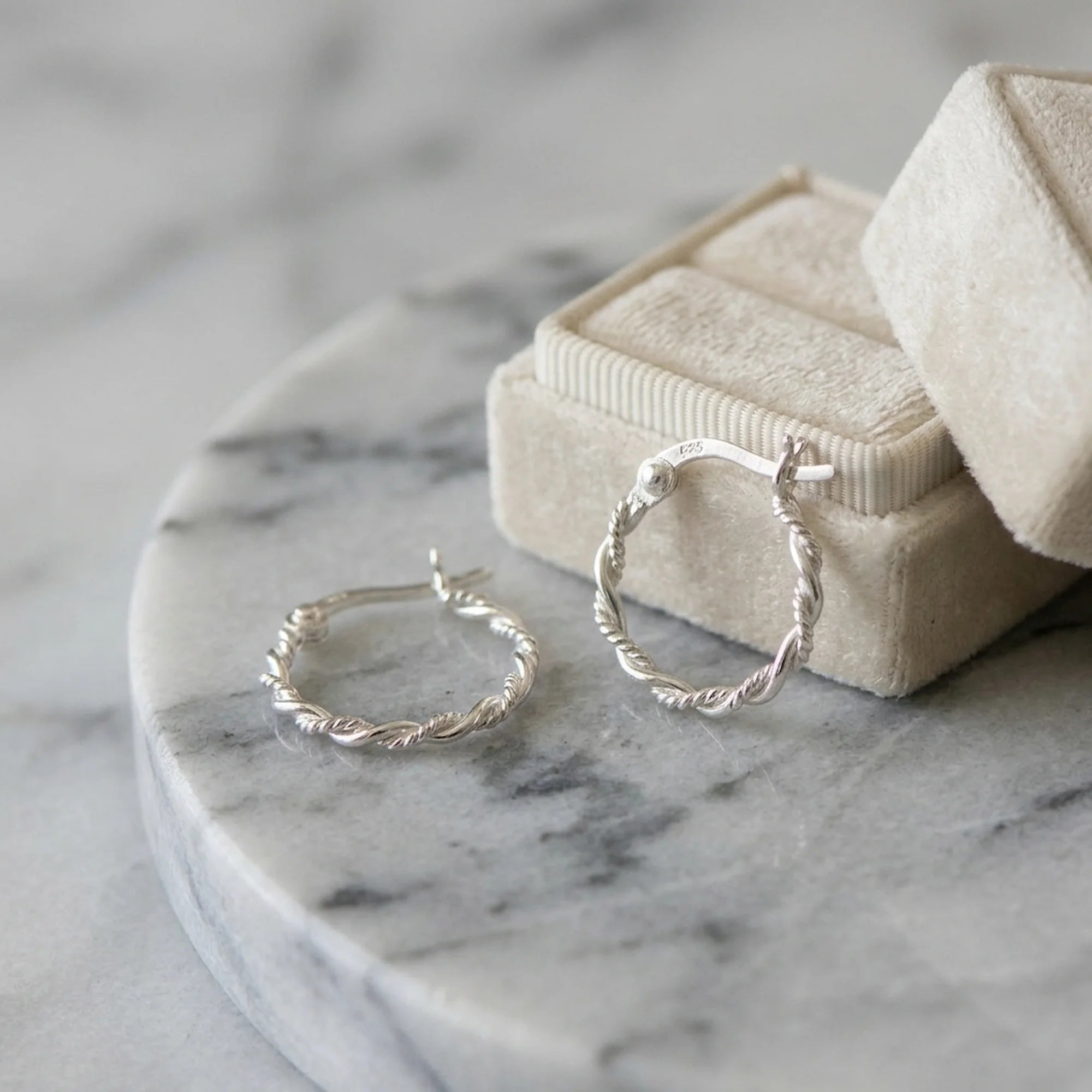 925 silver rope twist stacking hoop earrings resting near a jewelry box, an everyday gift for her in Dubai.
