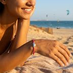 Woman wearing the silver heart pink cord bracelet on the beach at Kite Beach Dubai