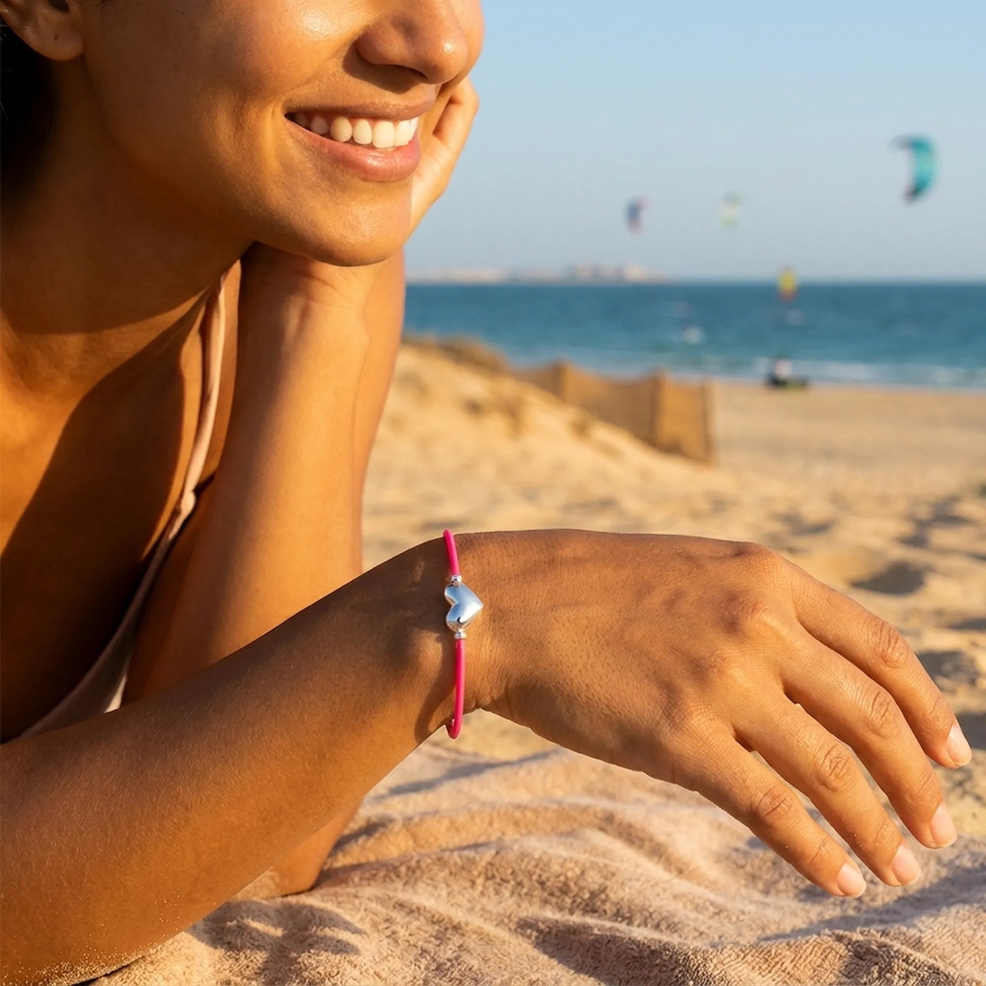 Woman wearing the silver heart pink cord bracelet on the beach at Kite Beach Dubai
