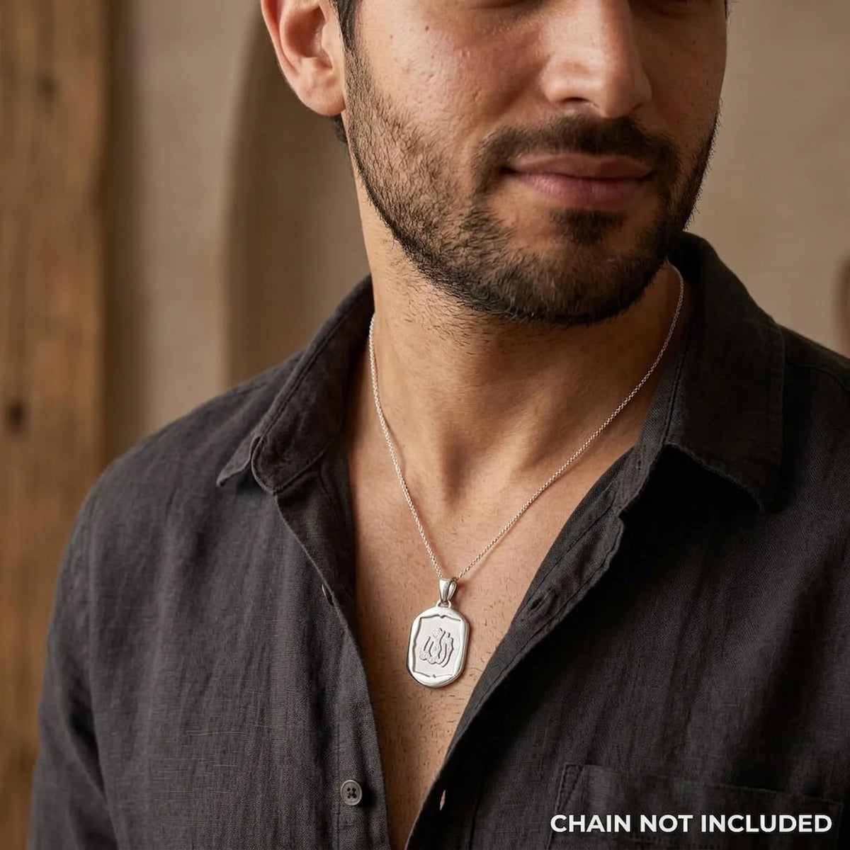 Man wearing a shield-framed 925 silver Allah charm pendant on a styling chain that is not included.