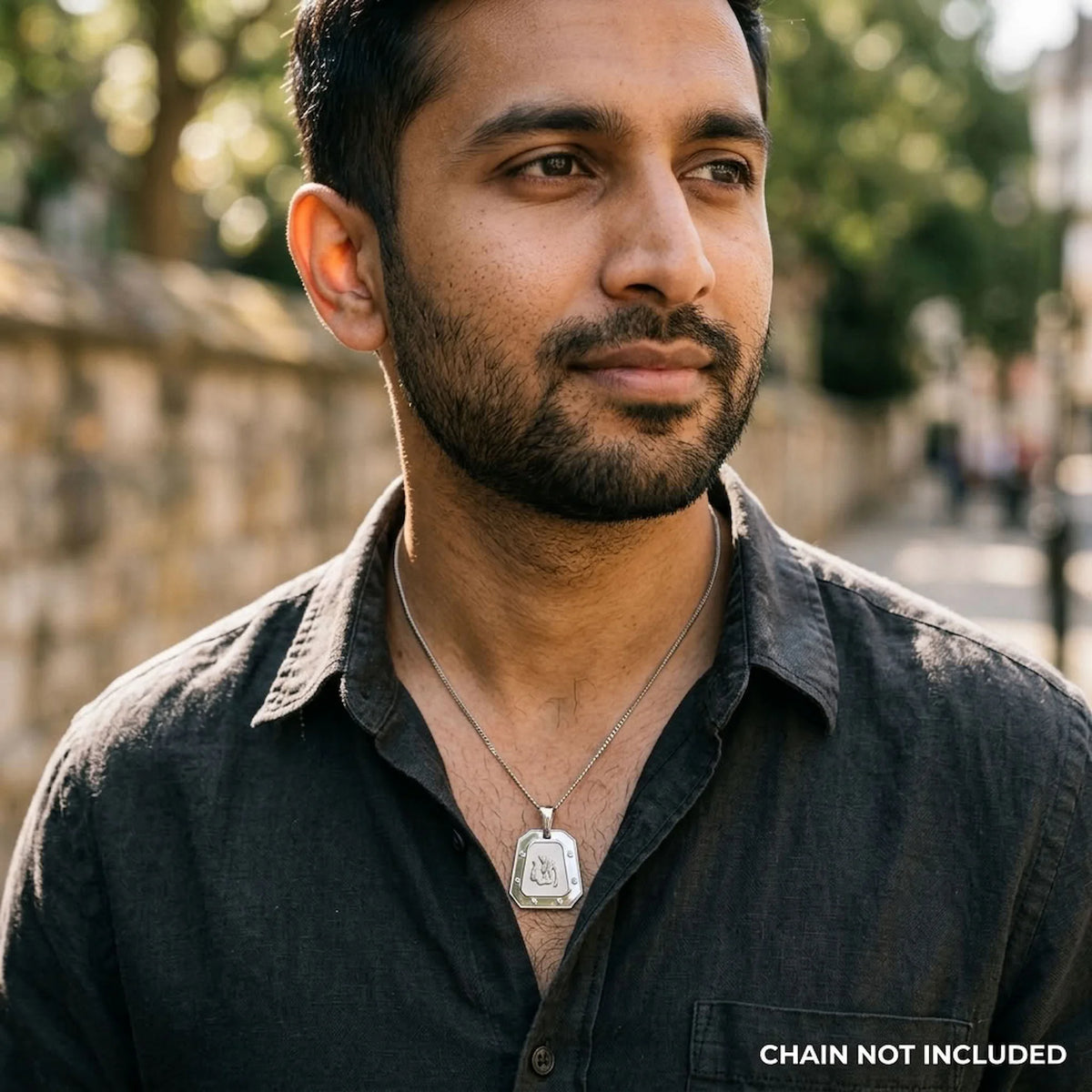 Man wearing the geometric Allah pendant with polished screw-accent frame on a styling chain that is not included.