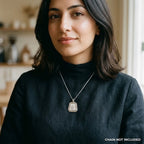Woman wearing a silver Allah pendant with six screw-head motifs and satin centre; styling chain not included.