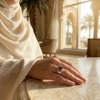 Woman in cream hijab resting hand on marble table wearing amethyst ring at Emirates Palace Abu Dhabi Moorish interior