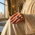 Hand wearing amethyst cocktail ring in embroidered abaya at Emirates Palace Abu Dhabi with golden palatial interior