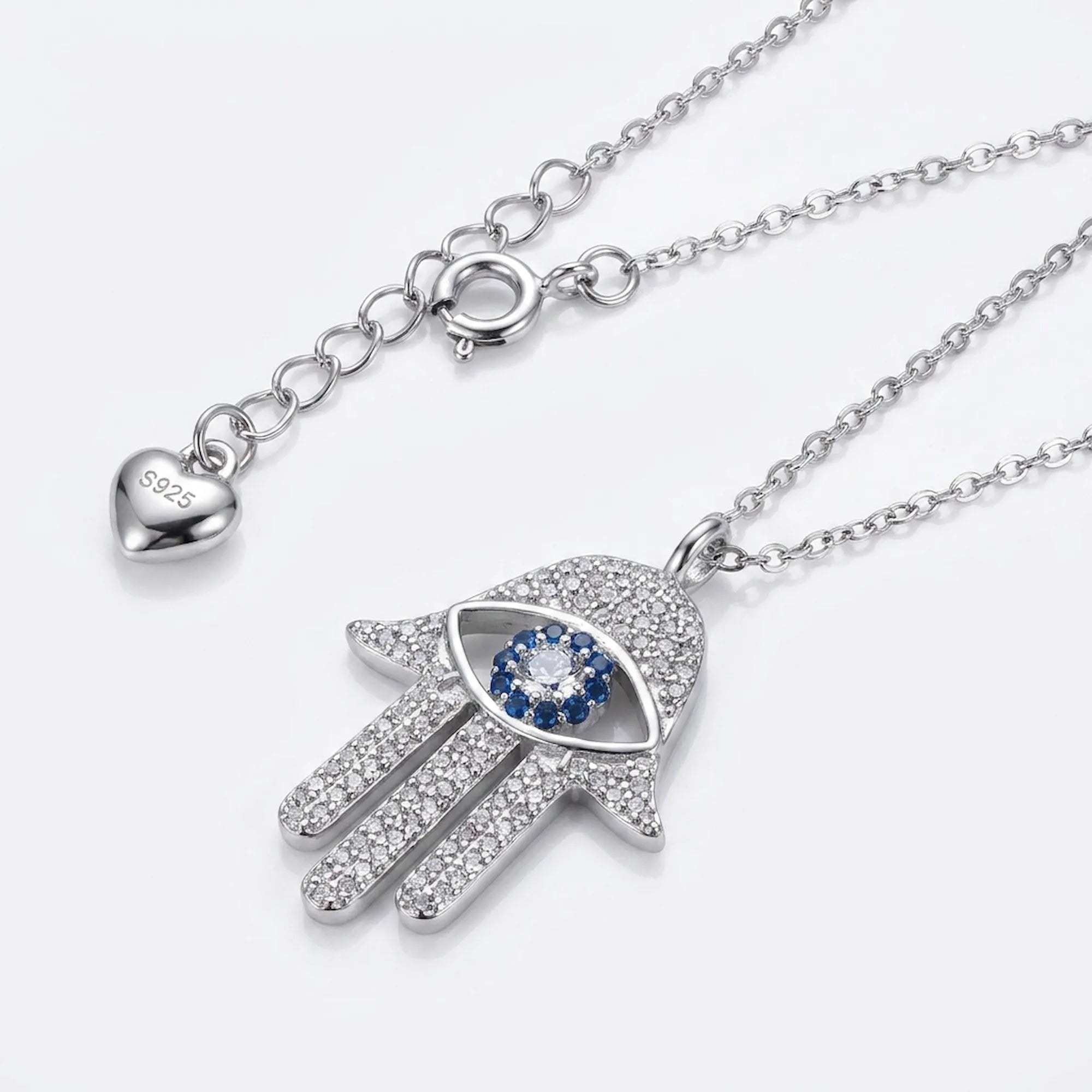 Silver necklace with Hamsa hand pendant featuring a blue gemstone on a white background