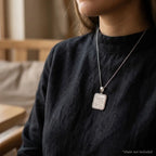 Woman wearing a sterling silver Ayat Al Kursi rounded-square pendant on a styling chain that is not included.