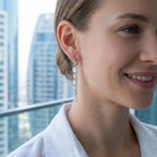 Model wearing baguette chain dangle earrings at Dubai Marina — 59mm CZ column and chain drop against high-rise skyline, rhodium 925 silver