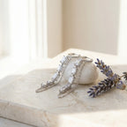 Baguette chain dangle earrings on marble surface with white ceramic and dried lavender — rhodium 925 silver CZ column and chain flat lay Dubai