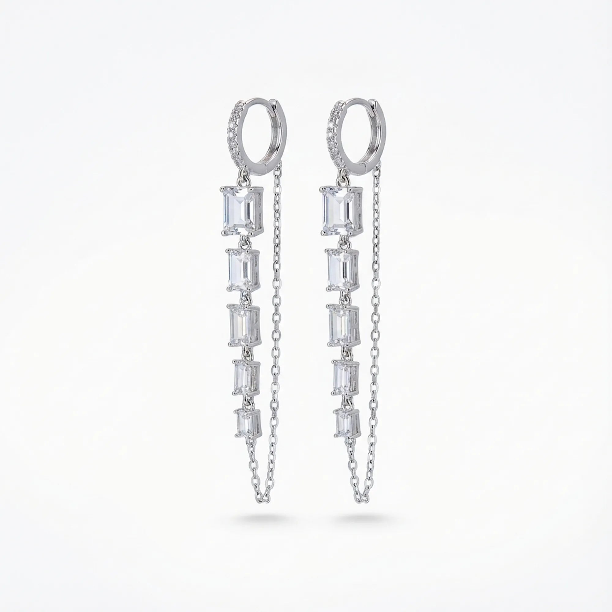 Baguette chain dangle earrings — pavé huggie hoop with five baguette CZ column and parallel cable chain, rhodium 925 silver on neutral background