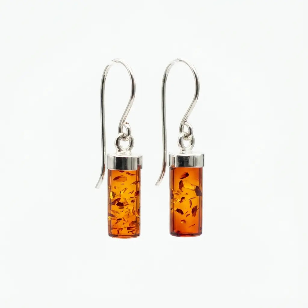 Pair of cognac Baltic amber cylinder drop earrings with sterling silver French hooks, displayed on a clean white background